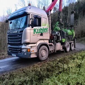Kübler-LKW mit Kran und Holzhäcksler auf einer Waldstraße